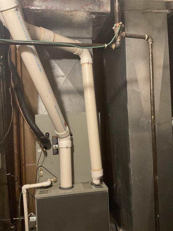 Conducted on-site evaluation of existing HVAC system for complete replacement. Assessed current Trane gas furnace with air handler and associated ductwork configuration in mechanical room. System has exceeded serviceable lifespan and requires full replacement rather than repair. Documented existing equipment specifications, venting arrangement with PVC condensate and exhaust piping, electrical connections, and gas line configuration. Evaluated mechanical room layout and clearances for new equipment installation. Provided consultation on upgrading to high-efficiency 2-stage or variable-speed heat pump system with gas furnace backup to improve comfort and energy performance. Photographed current installation including furnace unit, air filtration system, ductwork connections, and utility room configuration to support equipment sizing and replacement planning.