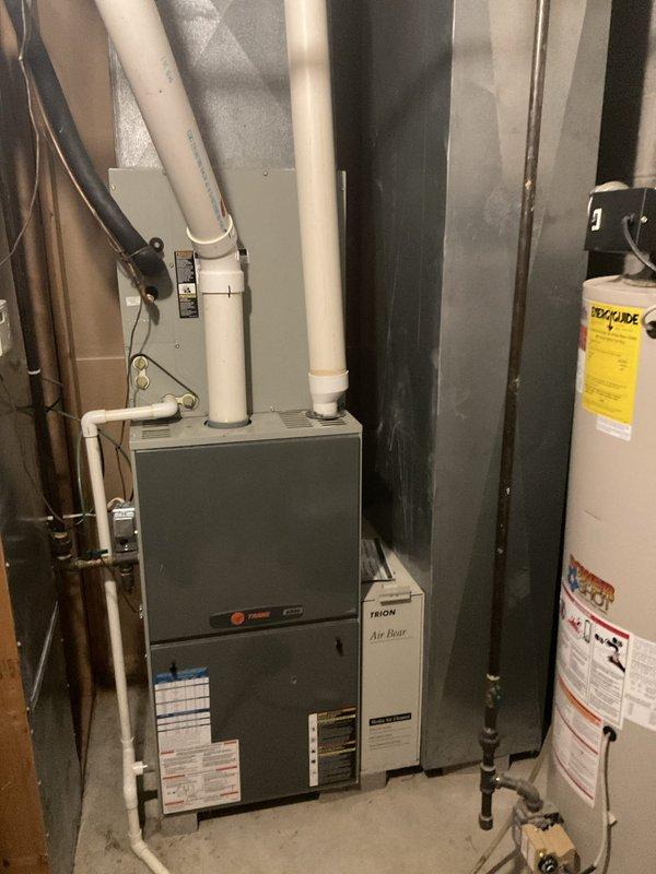Conducted on-site evaluation of existing HVAC system for complete replacement. Assessed current Trane gas furnace with air handler and associated ductwork configuration in mechanical room. System has exceeded serviceable lifespan and requires full replacement rather than repair. Documented existing equipment specifications, venting arrangement with PVC condensate and exhaust piping, electrical connections, and gas line configuration. Evaluated mechanical room layout and clearances for new equipment installation. Provided consultation on upgrading to high-efficiency 2-stage or variable-speed heat pump system with gas furnace backup to improve comfort and energy performance. Photographed current installation including furnace unit, air filtration system, ductwork connections, and utility room configuration to support equipment sizing and replacement planning.