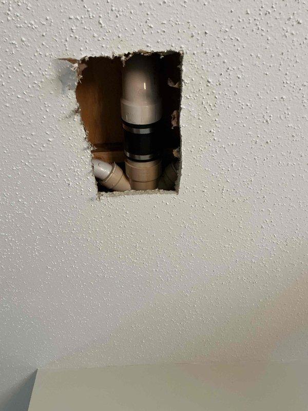 Responded to report of water staining on ceiling below bathroom. Upon inspection, identified active leak originating from toilet supply line connection above ceiling. Cut access opening in ceiling to expose plumbing components and confirmed leak source at compression fitting with degraded gasket. Replaced faulty gasket and compression fitting, tested system under pressure to verify proper seal and confirm leak resolution.