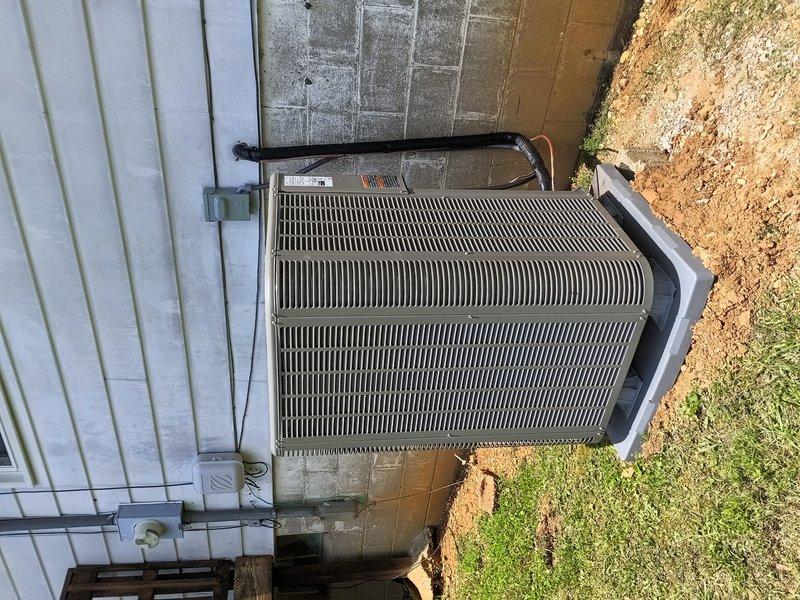 Completed full installation of Lennox heat pump system at residential property. Installed outdoor condensing unit on new concrete pad with proper clearances from building structure, mounted electrical disconnect box, ran refrigerant lines through exterior wall, and established all necessary electrical connections. System tested and confirmed operational upon completion.