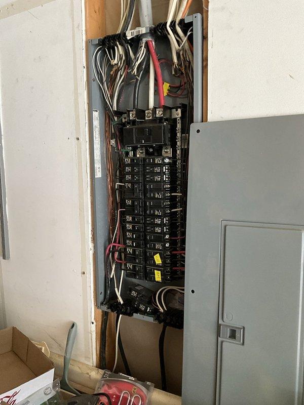Responded to service call for non-operational HVAC system with refrigerant leak using obsolete coolant type no longer manufactured. Provided comprehensive estimate for complete system replacement including new air handler unit and associated electrical work. Documented existing electrical panel configuration showing current breaker arrangement and wiring connections, as well as existing air handler installation in mechanical closet with drain pan assembly.