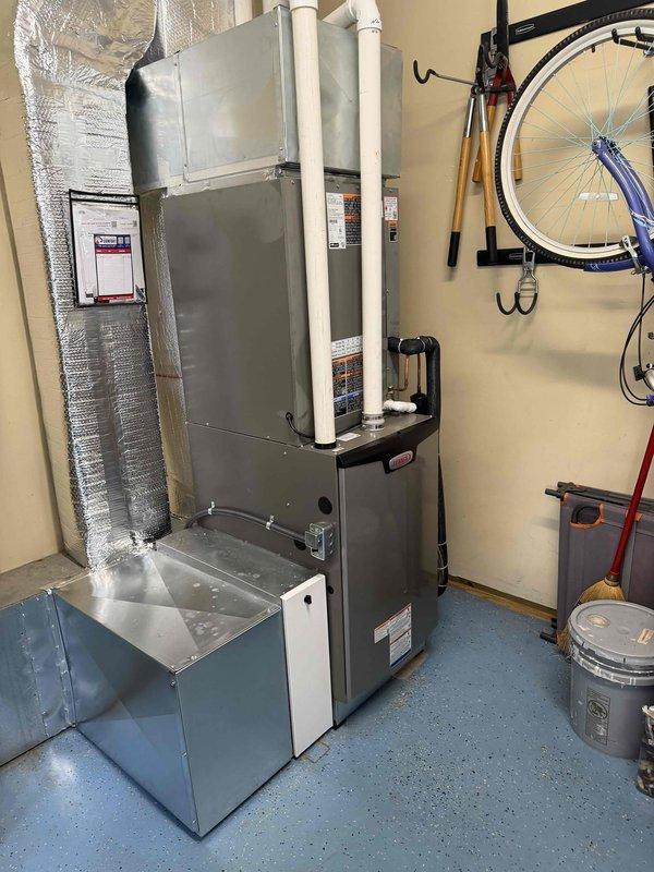 Completed full Lennox HVAC system installation with integrated zoning controls in residential utility space. Installed new gas furnace with proper venting using white PVC exhaust piping, connected insulated supply ductwork, and configured zoning system for multi-zone temperature control. Verified system operation with temperature readings showing proper airflow at 59°F supply air, ensured all manufacturer labels and safety documentation visible, and confirmed all components functioning correctly per specifications.