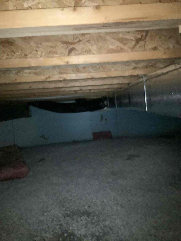 Responded to water leak complaint originating from air handler unit located in laundry room above crawl space. Upon arrival, inspected condensate drain pan and drain line system. Found condensate drain line partially obstructed despite homeowner's previous attempt to clear blockage. Performed complete drain line flush using appropriate cleaning methods to remove remaining debris and restore proper drainage flow. Inspected drain pan for signs of corrosion, rust-through, and structural integrity. Accessed crawl space beneath air handler to assess water damage and verify leak source. Confirmed standing water on concrete floor and moisture intrusion affecting adjacent living spaces including bedroom and bathroom areas. Verified drain line now flowing freely with no restrictions. Inspected HVAC ductwork and surrounding components in crawl space for any secondary moisture damage or corrosion. System tested and confirmed proper condensate drainage with no active leaking observed at time of se