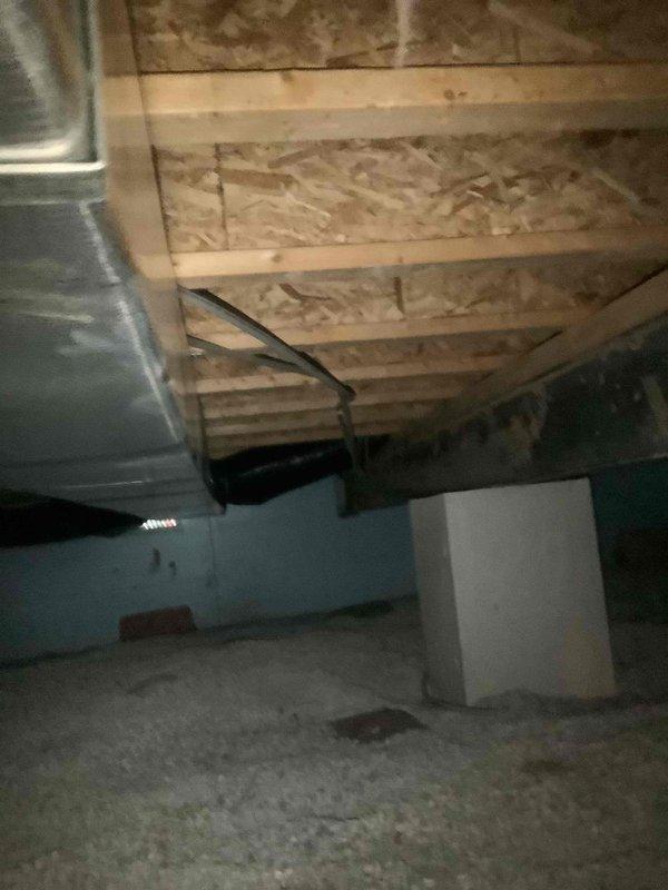 Responded to water leak complaint originating from air handler unit located in laundry room above crawl space. Upon arrival, inspected condensate drain pan and drain line system. Found condensate drain line partially obstructed despite homeowner's previous attempt to clear blockage. Performed complete drain line flush using appropriate cleaning methods to remove remaining debris and restore proper drainage flow. Inspected drain pan for signs of corrosion, rust-through, and structural integrity. Accessed crawl space beneath air handler to assess water damage and verify leak source. Confirmed standing water on concrete floor and moisture intrusion affecting adjacent living spaces including bedroom and bathroom areas. Verified drain line now flowing freely with no restrictions. Inspected HVAC ductwork and surrounding components in crawl space for any secondary moisture damage or corrosion. System tested and confirmed proper condensate drainage with no active leaking observed at time of se