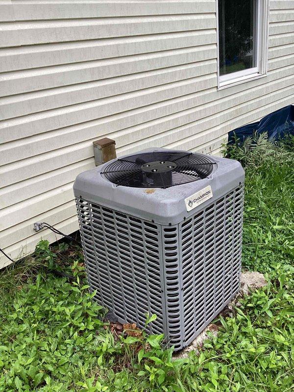 Performed standard air conditioning cleaning and check service on residential outdoor condenser unit. Inspected system components, cleaned condenser coils, verified electrical connections at disconnect box, and confirmed proper unit operation. Noted vegetation growth around unit base requiring customer attention to maintain adequate airflow clearance.