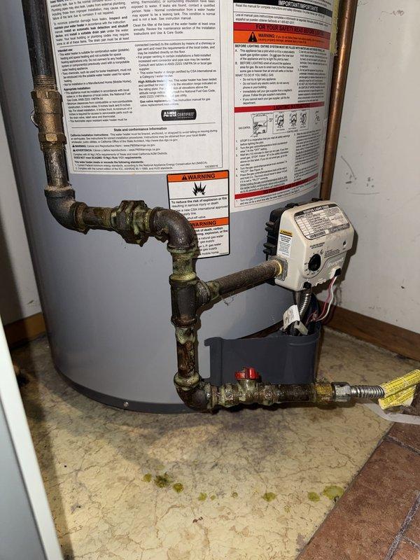 Responded to gas leak call at water heater location. Conducted thorough visual inspection of gas piping system, identifying aged copper and brass connections with visible corrosion and patina near water heater installation. Performed pressure test on gas lines to locate source of leak. Inspected gas valve, pipe joints, and connections at water heater and adjacent furnace system. Documented existing conditions showing deteriorated piping with significant oxidation requiring attention. Captured photographic evidence of corroded gas line components and overall system configuration for repair recommendations.