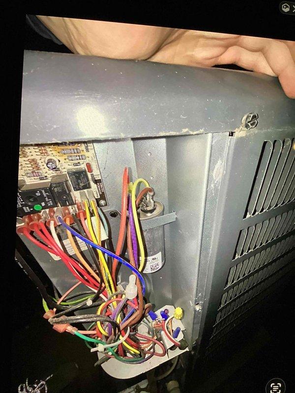 Responded to no cooling complaint on residential air conditioning system. Accessed control board compartment and inspected electrical connections, wiring harnesses, and control components. Verified proper wiring connections at terminal board with multiple low-voltage control wires secured with wire nuts. Inspected attic-mounted condenser unit including fan motor operation, condenser coil condition, and refrigerant line connections. System evaluated and restored to proper cooling operation.