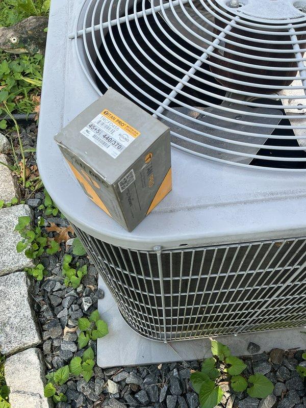 Replaced failed run capacitor on outdoor condensing unit with new TITAN PRO TRCFD455 capacitor. Removed old weathered capacitor and installed new unit, restoring proper compressor and fan motor operation. System tested and confirmed operating within normal parameters.