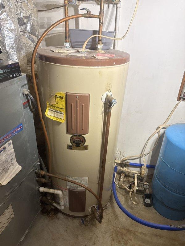 Conducted on-site evaluation of existing electric water heater installation for replacement estimate. Inspected current cylindrical tank-style water heater with copper supply connections, noting configuration of hot and cold water lines, pressure relief valve system, and electrical junction box. Assessed existing plumbing infrastructure including pressure tank, shut-off valves, and gauge assembly to determine compatibility requirements for new unit installation. Documented current system specifications and mechanical room layout to provide accurate replacement recommendations and ensure proper sizing for residential hot water demands.