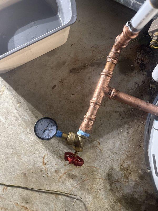 Conducted on-site evaluation of existing electric water heater installation for replacement estimate. Inspected current cylindrical tank-style water heater with copper supply connections, noting configuration of hot and cold water lines, pressure relief valve system, and electrical junction box. Assessed existing plumbing infrastructure including pressure tank, shut-off valves, and gauge assembly to determine compatibility requirements for new unit installation. Documented current system specifications and mechanical room layout to provide accurate replacement recommendations and ensure proper sizing for residential hot water demands.