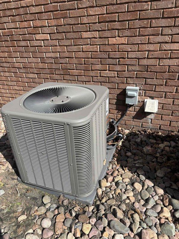 Completed full HVAC system installation consisting of Lennox air conditioning condensing unit and gas furnace. Positioned outdoor condensing unit on landscaped river rock bed against building foundation with proper clearances, installed electrical disconnect box on exterior wall, and ran refrigerant lines and electrical conduit to interior equipment. Installed gas furnace indoors with all necessary connections and venting per manufacturer specifications. Mounted Honeywell Home digital thermostat on interior wall, wired to new system, and programmed for cooling operation. Verified all electrical connections at disconnect and unit, checked refrigerant line integrity, and tested system startup. Confirmed proper airflow, temperature differential, and thermostat communication with equipment. System operating within normal parameters and ready for service.