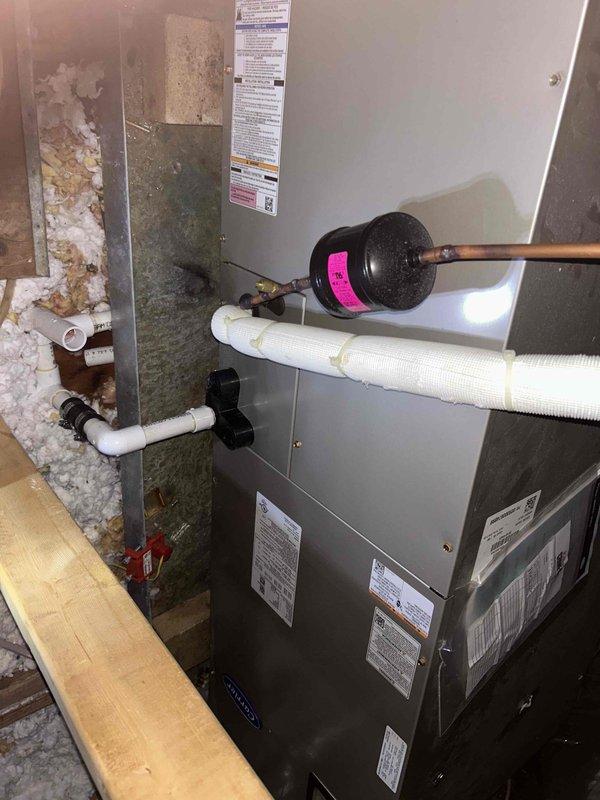 Responded to callback for air handler leaking and water stains appearing on living room ceiling. Upon arrival, located air handler unit in attic space and identified active condensate drainage issue. Inspected condensate drain system including primary drain line and overflow safety switch. Found condensate backup causing water to overflow from drain pan, resulting in water intrusion through ceiling below. Cleared blockage from condensate drain line and verified proper drainage flow. Flushed drain system and collected standing water from affected area. Tested air handler operation and confirmed condensate is now draining properly through primary drain line without overflow. Advised homeowner that ceiling damage will require separate repair once area fully dries.