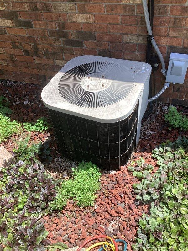 Responded to no cooling complaint on residential air conditioning system. Upon arrival, found outdoor condenser unit installed against brick exterior wall with landscaping. Performed diagnostic evaluation of system operation and checked refrigerant levels. Noted previous leak seal application from prior service visit and verified warranty status on materials. Completed full maintenance service including cleaning condenser coils, inspecting electrical connections at disconnect box, and verifying proper airflow through condenser fan. Checked thermostat operation and confirmed temperature settings at indoor unit. System restored to proper cooling operation with all components functioning within normal parameters.