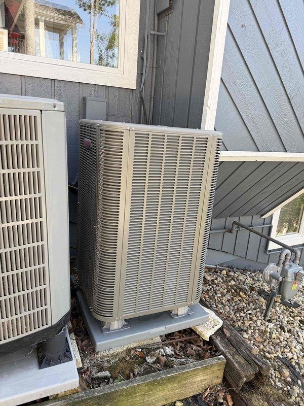 Completed full installation of Lennox heat pump system for upstairs zone. Installed new Lennox air handler unit in interior utility closet with proper vertical mounting and secure positioning. Connected insulated ductwork with metallic flexible insulation extending to distribution system. Established proper condensate drainage with drain pan installation. Completed all electrical connections and control wiring per manufacturer specifications.

Installed outdoor heat pump condenser unit on concrete pad against exterior wall with gray-blue siding. Positioned unit alongside existing HVAC equipment with adequate clearance for service access and airflow. Ran refrigerant line set from outdoor unit to indoor air handler, including insulated copper piping with proper routing along exterior wall. Secured all refrigerant connections and performed leak testing. Applied decorative rock ground cover around equipment pad for drainage and aesthetics.

System tested and verified operational with prope