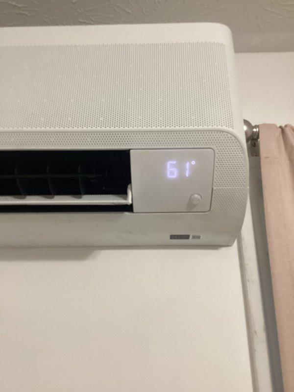 Responded to no-cooling complaint on wall-mounted ductless mini-split system. Upon arrival, verified unit was displaying 61°F on digital readout but not producing cooled air. Performed diagnostic inspection of indoor air handler, confirmed unit under warranty coverage, and documented system condition with photos showing proper mounting and display function for warranty claim processing.
