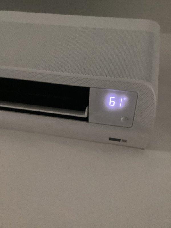 Responded to no-cooling complaint on wall-mounted ductless mini-split system. Upon arrival, verified unit was displaying 61°F on digital readout but not producing cooled air. Performed diagnostic inspection of indoor air handler, confirmed unit under warranty coverage, and documented system condition with photos showing proper mounting and display function for warranty claim processing.
