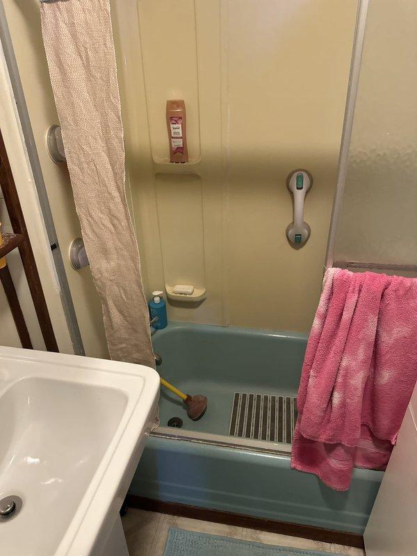 Conducted free on-site estimate for converting existing turquoise bathtub to shower installation in residential bathroom. Assessed current plumbing configuration, measured fixture dimensions, photographed existing setup including tub surround, drainage system, and available space constraints. Documented bathroom layout to prepare comprehensive conversion proposal including demolition of existing tub, shower pan installation, and necessary plumbing modifications.