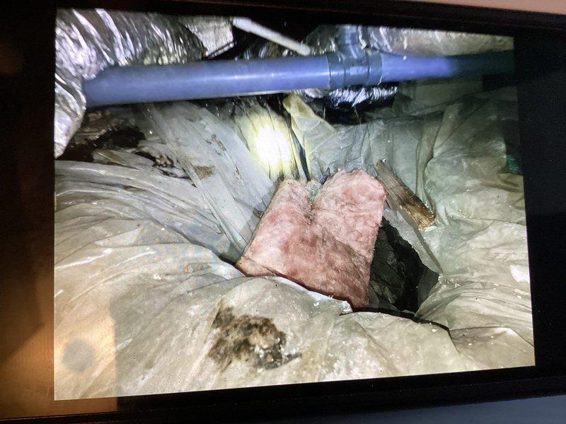 Responded to callback for furnace water leak near coils with pooling occurring under unit and in sink below coils despite previous drain pipe clearing attempt. Upon inspection, identified persistent drainage issue in condensate system. Accessed attic space and located blue PVC condensate drain line with existing mounting hardware. Thoroughly inspected drain line routing, connections, and termination point. Verified proper pitch and cleared any remaining blockages in condensate drainage system. Tested system operation and confirmed water now draining properly through pipe without pooling. Verified thermostat settings at 75°F with system functioning correctly. Documented conditions with photos of thermostat display and attic condensate line installation for service records.