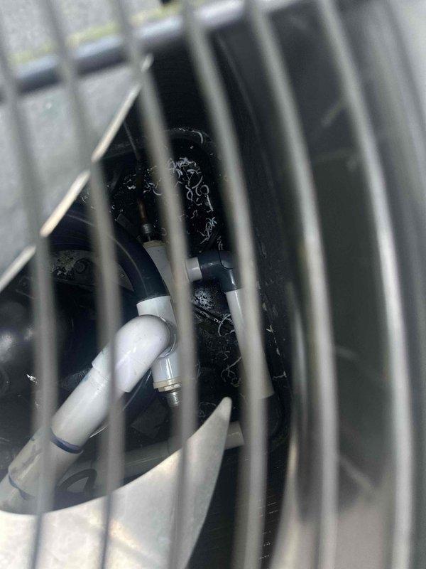Performed warranty inspection on HVAC system air handler unit. Documented interior cabinet condition, noting standing water accumulation in drain pan with visible debris and sediment. Inspected refrigerant lines (copper and insulated), PVC condensate drainage piping, and condensate trap assembly for proper configuration and function. Photographed mechanical components within protective housing to document system status and drainage concerns for warranty evaluation.