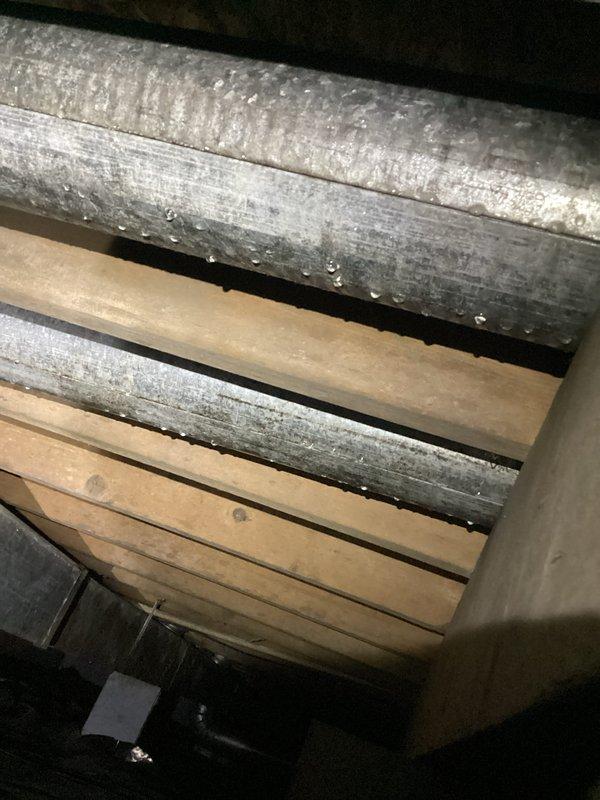 Returned to address excessive condensation on supply ductwork in crawlspace. Upon inspection, found heavy moisture accumulation and water droplets on metallic duct surfaces due to inadequate insulation and high humidity conditions. Documented existing conditions with photographs showing extent of condensation damage and potential for wood deterioration on adjacent floor joists. Recommended proper duct insulation upgrade and dehumidification solutions to prevent ongoing moisture issues and protect structural integrity of surrounding wooden framing members.