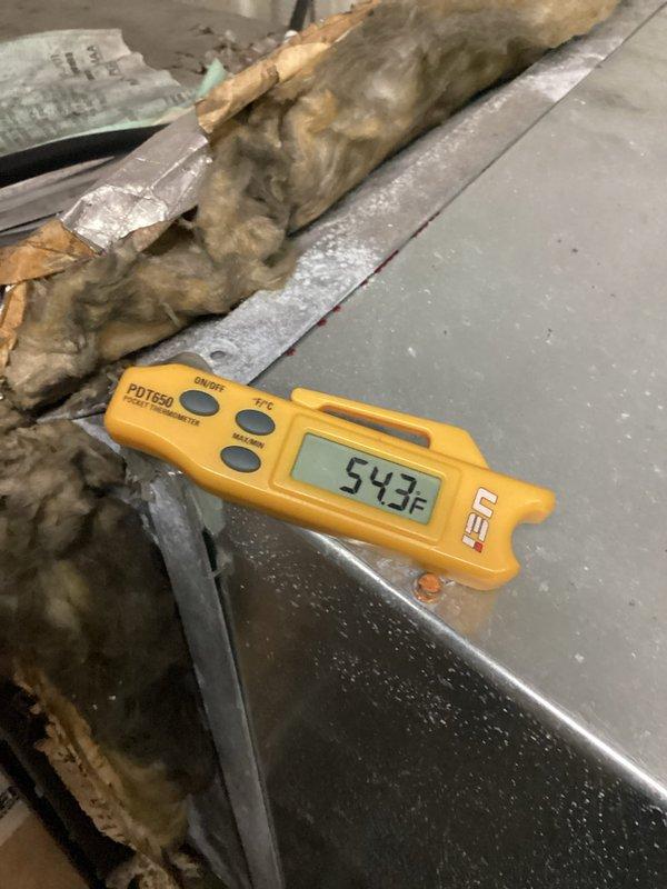 Responded to no cooling complaint for front retail area where thermostat was set to 71°F but space temperature had risen to 79°F. Upon inspection, discovered supply air temperature measuring 54.3°F at the duct, indicating the AC unit was producing adequate cooling. Identified thermostat location and programming issues preventing proper temperature control in the customer-facing zone. System operational with cold air being delivered to ductwork.