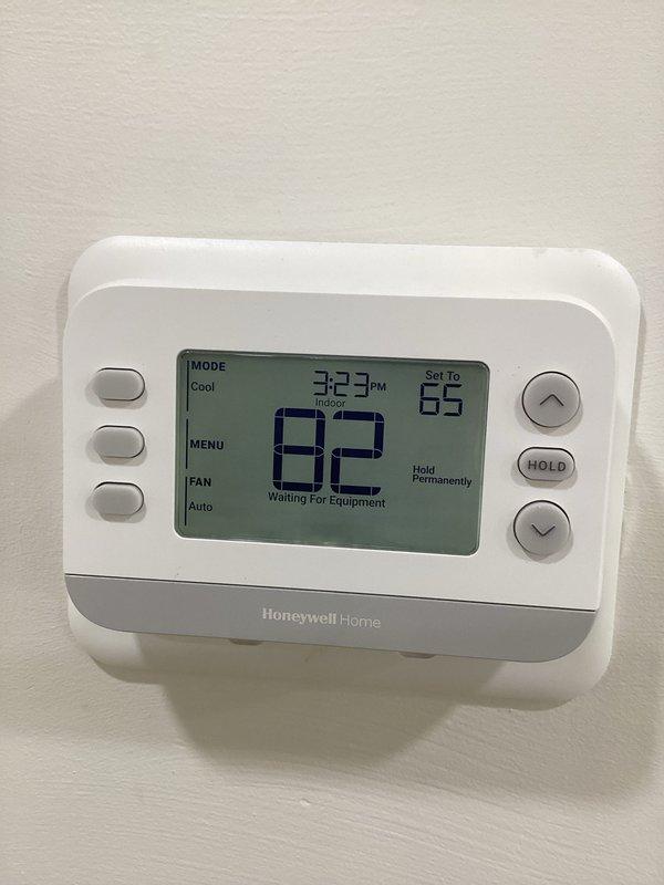 Responded to no cooling complaint after customer self-installed replacement thermostat. Upon arrival, found system blowing hot air with thermostat displaying "Waiting For Equipment" message despite being set to cool mode at 66°F while indoor temperature read 82°F. Diagnosed thermostat wiring issue resulting from improper installation. Verified thermostat configuration, corrected wiring connections to ensure proper communication between thermostat and HVAC equipment. Confirmed evaporator coil and air handler components operational. System restored to normal cooling operation with proper thermostat function established.