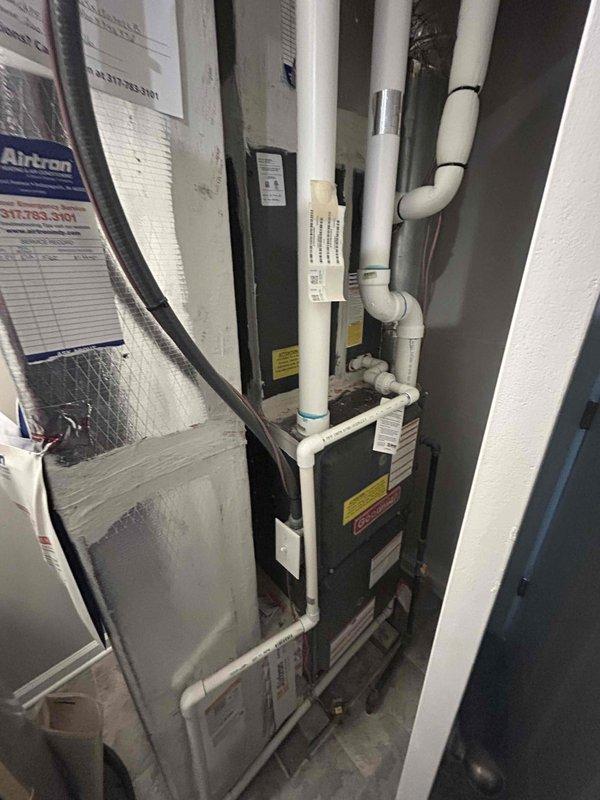 Responded to no cooling complaint on aging HVAC system located in utility closet. Upon inspection, found vertical air handler with foil-backed insulation and furnace unit with multiple system components including PVC condensate drainage lines and refrigerant lines. Evaluated system performance and inspected insulation materials showing wear and compression on reflective foil facing, which may impact system efficiency and contribute to cooling issues on this 10+ year old equipment.