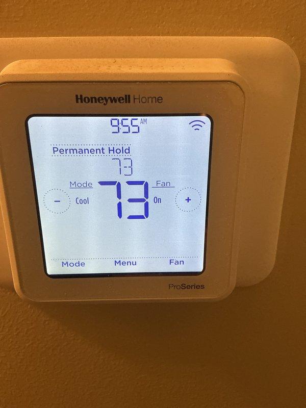 Responded to warranty service call for AC system running continuously without cycling off. Diagnosed Honeywell Home ProSeries thermostat programmed with permanent hold setting and fan mode set to "On" instead of "Auto," preventing normal system cycling. Corrected thermostat configuration by removing permanent hold, adjusting temperature settings, and switching fan operation to auto mode to allow proper system cycling. Verified refrigerant charge within manufacturer specifications, confirmed adequate airflow across evaporator coil, and inspected installation for compliance with warranty requirements—all components found operating correctly. System now cycling properly with thermostat controlling compressor operation as designed.