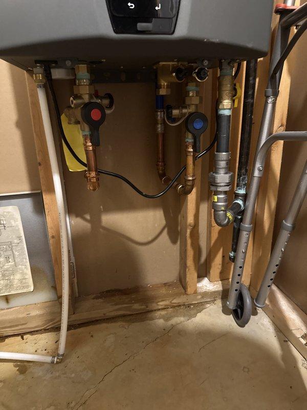 Performed maintenance flush on tankless water heater unit and completed installation of new water conditioning system. Connected water conditioner to existing copper supply lines using brass fittings and shut-off valves, integrating the treatment system with the tankless heater plumbing infrastructure to provide whole-house water conditioning.