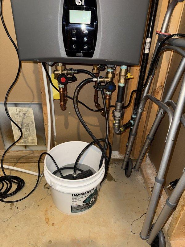 Performed maintenance flush on tankless water heater unit and completed installation of new water conditioning system. Connected water conditioner to existing copper supply lines using brass fittings and shut-off valves, integrating the treatment system with the tankless heater plumbing infrastructure to provide whole-house water conditioning.