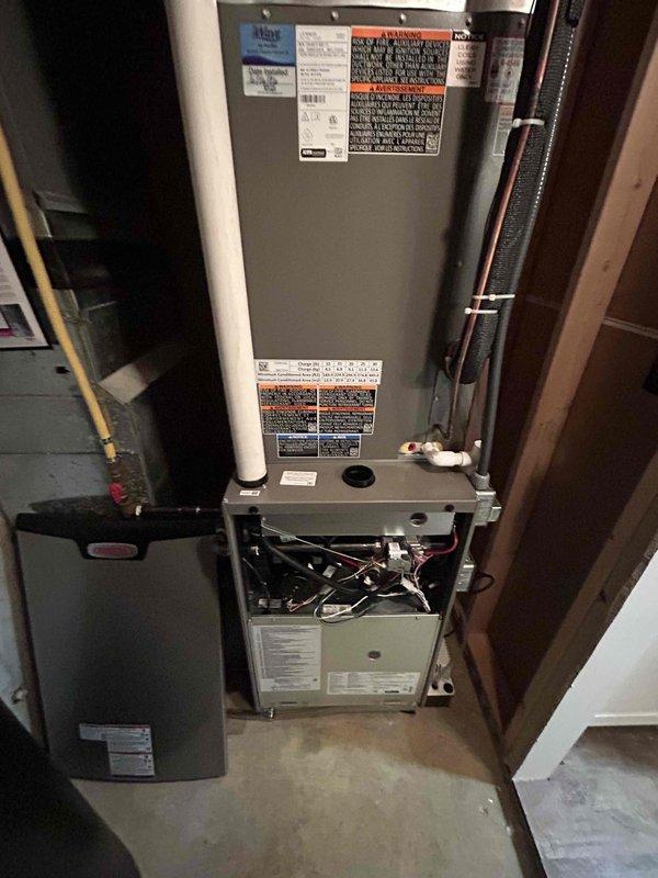 Responded to callback regarding newly installed split system air conditioner experiencing intermittent communication loss between outdoor condensing unit and indoor air handler, resulting in unexpected system shutdowns. Inspected electrical connections at outdoor unit and indoor furnace, examining terminal block wiring harness with multiple low-voltage control wires and verifying proper connections between thermostat, condenser, and air handler. Troubleshot communication wiring between components, checked refrigerant line set installation, and documented existing wiring configuration for warranty follow-up on two-week-old installation.