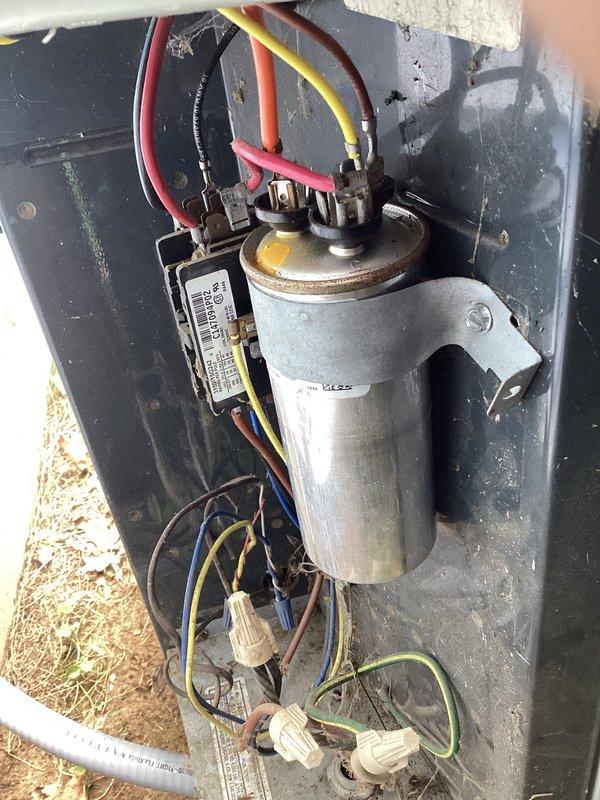 Responded to no-cooling call on outdoor condensing unit. Upon arrival, found condenser fan motor improperly mounted and free-floating inside unit housing after recent motor replacement by homeowner. Motor assembly not secured correctly to top panel mounting brackets, creating potential for damage to electrical connections and internal components. Inspected new capacitor installation and verified proper electrical connections to compressor and fan motor terminals. Documented improper motor mounting configuration with photos showing cross-shaped support bracket system and loose motor housing. Advised that motor must be properly secured to manufacturer specifications before unit operation to prevent equipment damage and ensure safe functionality.