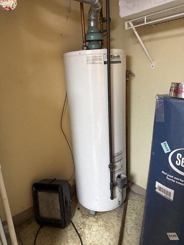 Responded to service call regarding A.O. Smith Permaglas electric tanked water heater with improper venting configuration identified by gas utility company during meter replacement. Upon inspection, confirmed water heater unit operational but venting ductwork improperly installed with flexible metallic duct incorrectly routed from top of unit. Documented existing conditions showing inadequate venting system that prevented utility from restoring gas service to property.