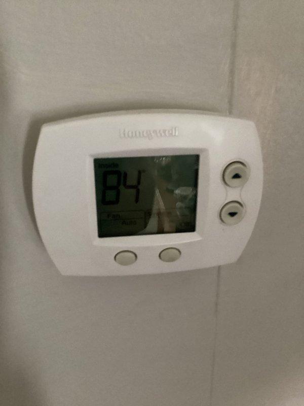 Responded to no cooling complaint on commercial HVAC unit. Upon arrival, found thermostat displaying 84°F and investigated the system. Documented existing conditions with photos of thermostat controls and what appears to be the cooling equipment installation for service records.