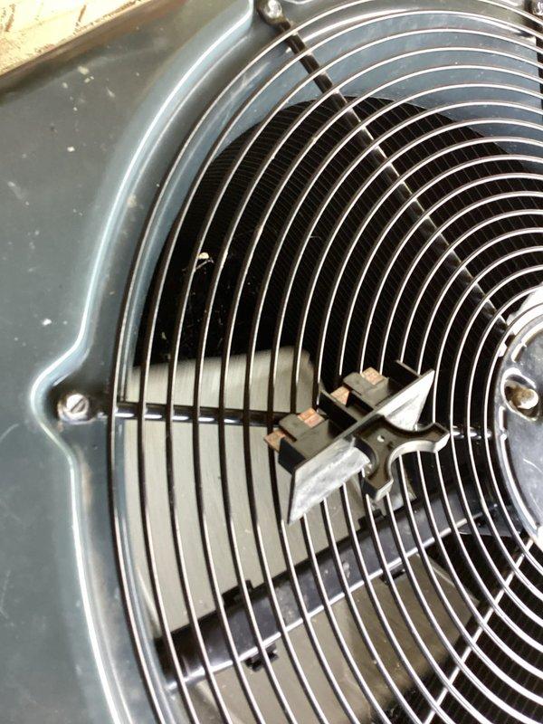 Responded to no cooling complaint on commercial HVAC unit. Upon arrival, inspected condenser fan assembly and found motor had failed, preventing proper heat rejection from the system. Verified thermostat was calling for cooling at 75 degrees but unit was unable to satisfy demand due to inoperative condenser fan. Documented equipment condition with photos showing fan guard assembly and thermostat display for service records.