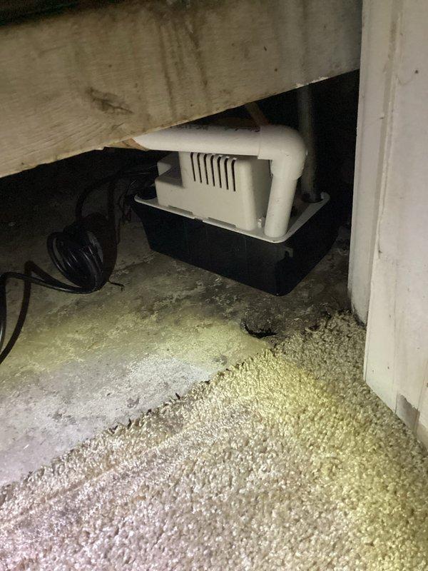 Responded to no cooling call at residential apartment unit. Upon inspection, found condensate pump in attic space operational with proper drainage setup via PVC piping. Verified thermostat displaying 74°F with system powered and responsive to controls. Checked air handler and condensate removal system, confirmed all components functioning within normal parameters and unit cooling effectively.