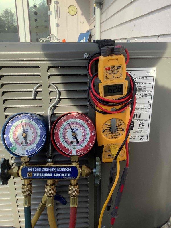 Performed air conditioning system diagnostic and testing on outdoor condensing unit. Utilized manifold gauge set to check refrigerant pressures on both high and low sides of the system, and employed digital multimeter to verify electrical readings and component operation. Inspected condenser fan assembly, noting minor debris accumulation between cooling fins, and documented unit condition with visual records for service history.