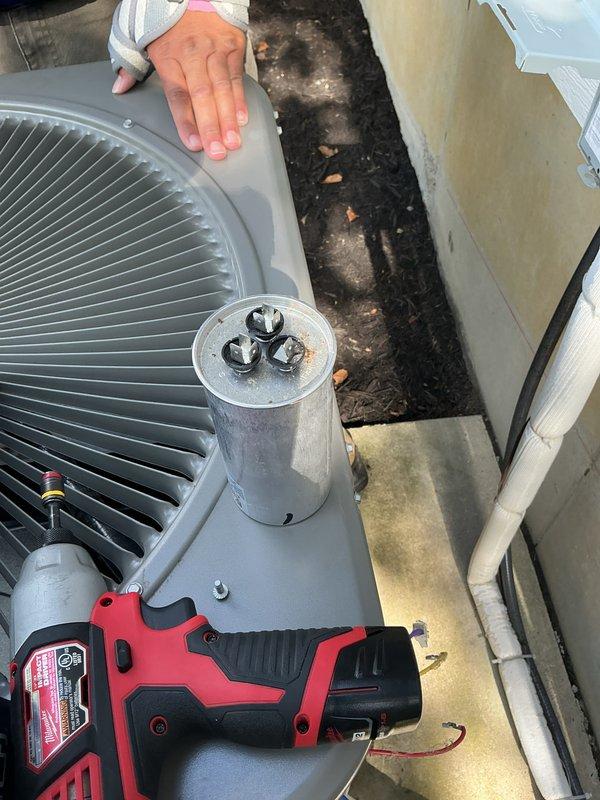 Replaced defective dual-run capacitor rated at 70/10 MFD on residential outdoor condensing unit under warranty coverage. Removed failed capacitor, installed new unit, and verified proper electrical connections and system operation. Confirmed thermostat displaying correct temperature reading and system cycling properly upon completion.