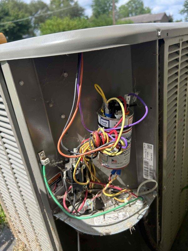 Responded to no-cooling complaint with indoor temperature reported above 87 degrees. Inspected outdoor condensing unit and accessed electrical compartment to evaluate capacitor and wiring connections. Documented unit condition and electrical components for diagnostic purposes.