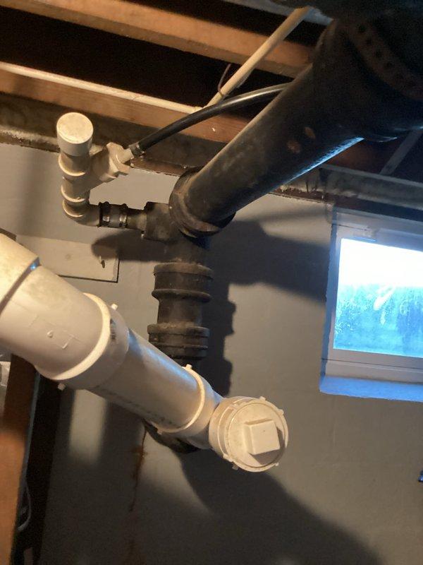 Completed annual plumbing inspection of residential property, examining all accessible plumbing infrastructure including basement utility area. Inspected exposed drainage systems, PVC piping, cast iron waste lines, ceiling-mounted plumbing fixtures, and sump pump assembly. All components photographed and documented, showing older cast iron pipes with age-related wear and newer PVC installations with proper fittings and clean-outs in good working condition.