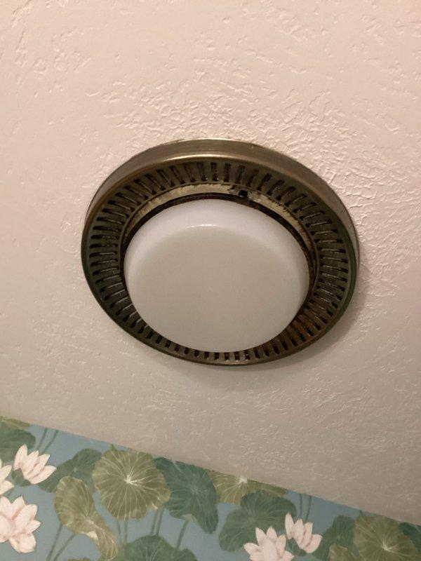 Replaced two original bathroom exhaust fans with new ceiling-mounted fixtures featuring decorative bronze trim and white dome covers. Inspected toilet flushing mechanism to diagnose extended flush cycle issue.