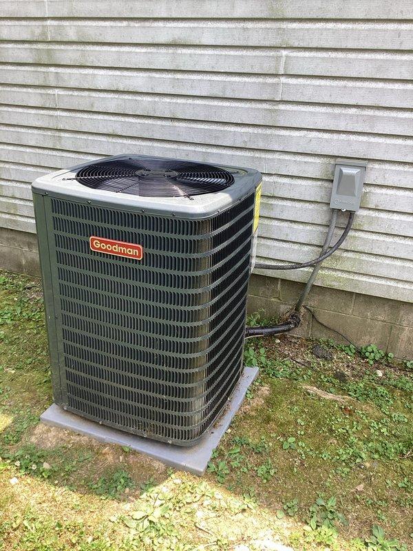 Responded to service call for Goodman condensing unit experiencing short cycling issue where system would run for 15-20 seconds without producing cold air. Diagnosed thermostat compatibility problem with recently installed control that was causing improper system operation. Documented equipment installation and electrical disconnect configuration for service records.