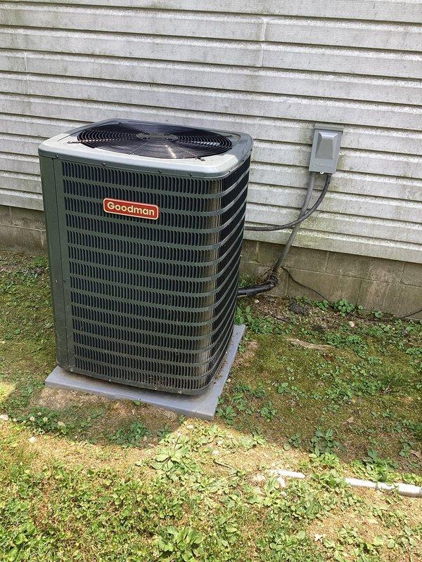 Responded to service call for Goodman condensing unit experiencing short cycling issue where system would run for 15-20 seconds without producing cold air. Diagnosed thermostat compatibility problem with recently installed control that was causing improper system operation. Documented equipment installation and electrical disconnect configuration for service records.