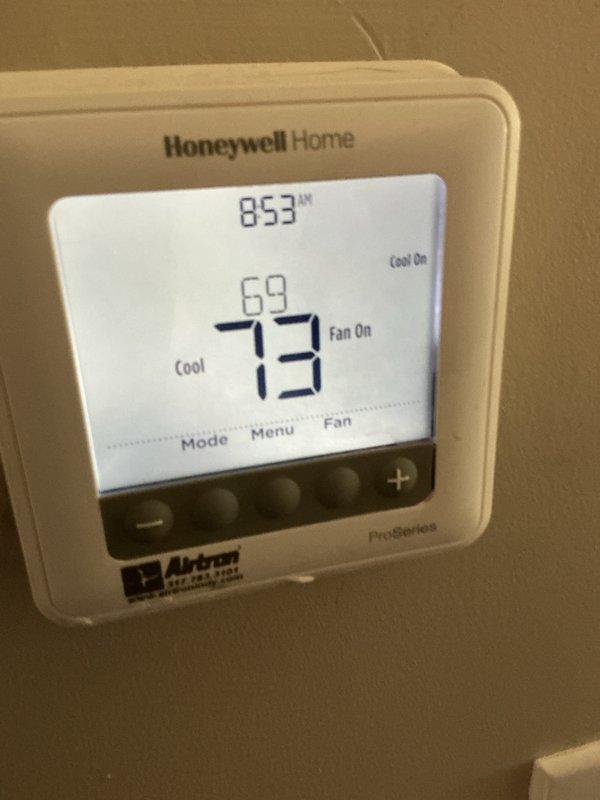 Responded to service call for new air conditioning system not maintaining adequate cooling capacity. Inspected outdoor Goodman condenser unit and verified operational status of all components. Evaluated Honeywell thermostat settings and confirmed system configuration with fan operating continuously in cooling mode at 73°F setpoint.