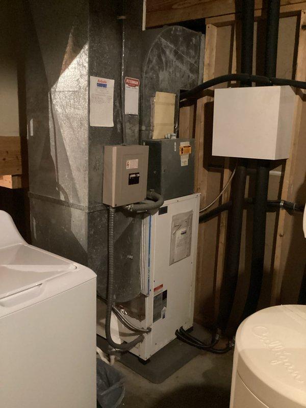 Responded to service call for residential cooling system not maintaining temperature, with indoor conditions reaching 81°F despite thermostat set to 76°F. Previous temporary repair had failed to resolve the issue. Inspected R-22 system in basement utility area and evaluated air handler operation. System assessed for refrigerant levels and overall functionality. Documented current equipment condition with photos showing thermostat display and basement mechanical equipment installation. Advised customer that system may require additional R-22 refrigerant charge to maintain cooling capacity as temporary measure until scheduled geothermal replacement unit arrives, with alternative option of supplemental window unit for interim cooling needs.