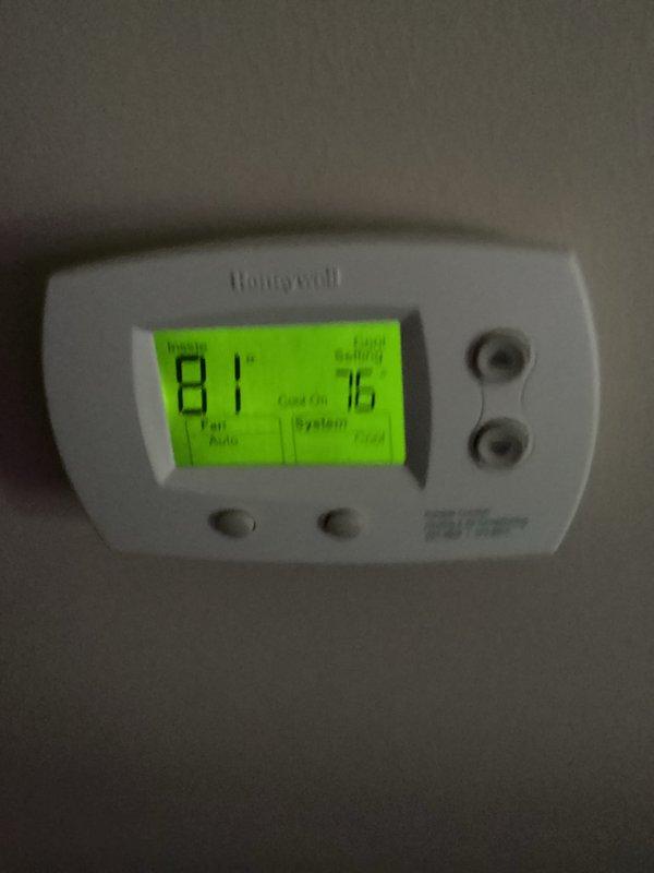 Responded to service call for residential cooling system not maintaining temperature, with indoor conditions reaching 81°F despite thermostat set to 76°F. Previous temporary repair had failed to resolve the issue. Inspected R-22 system in basement utility area and evaluated air handler operation. System assessed for refrigerant levels and overall functionality. Documented current equipment condition with photos showing thermostat display and basement mechanical equipment installation. Advised customer that system may require additional R-22 refrigerant charge to maintain cooling capacity as temporary measure until scheduled geothermal replacement unit arrives, with alternative option of supplemental window unit for interim cooling needs.