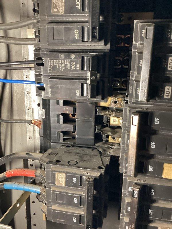 Replaced failed 30-amp three-pole circuit breaker serving commercial air conditioning unit in electrical panel. Removed damaged breaker exposing internal bus connections, installed new BR-type three-phase breaker, verified proper wire terminations, and restored power to AC system with all connections secure and operational.