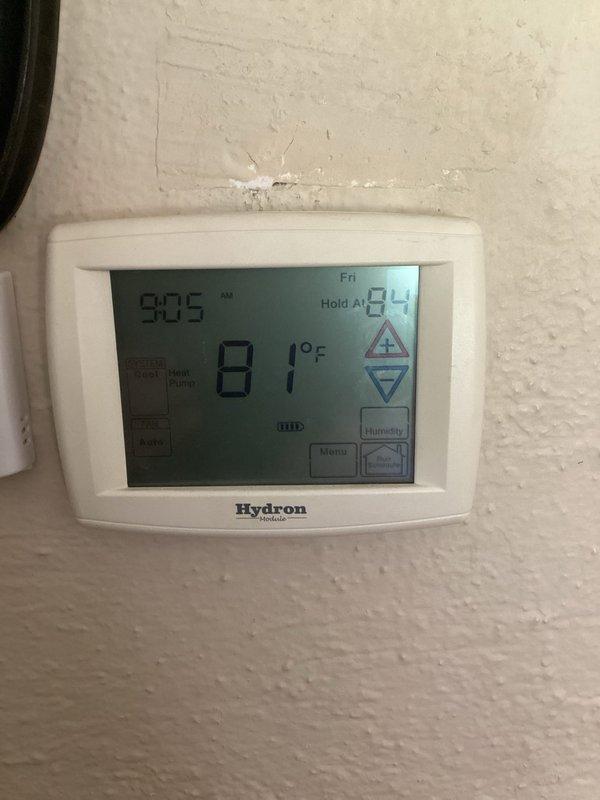 Responded to service call for Hydrox Revolution geothermal unit experiencing flashing error code and loss of cooling capability. Upon arrival, found Hydron thermostat displaying 81°F with setpoint at 93°F hold, indicating system malfunction. Inspected downstairs geothermal heat pump unit and diagnosed intermittent fault that had been occurring for approximately one and a half weeks. Customer had temporarily resolved issue by cycling breakers, but system failed again and ceased cooling. Performed diagnostic evaluation of unit controls, electrical connections, and thermostat communication. Documented system conditions with photos of thermostat display and geothermal unit for service records.