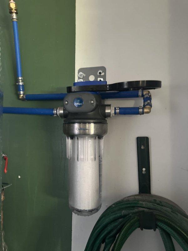 Responded to warranty service call for water filtration system installed in May. Removed over-tightened filter housing cap, replaced filter cartridge, and reassembled unit with appropriate torque to allow for future customer-performed filter changes. Verified system operation and confirmed housing cap can now be removed by hand for routine maintenance.