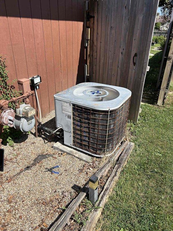 Responded to no cooling complaint on residential air conditioning system. Performed diagnostic evaluation of outdoor condensing unit and indoor thermostat operation. Verified thermostat settings showing 73°F setpoint with fan in auto mode, inspected outdoor unit installation including refrigerant line connections and electrical conduit, and assessed overall system condition to determine cause of inadequate cooling performance.